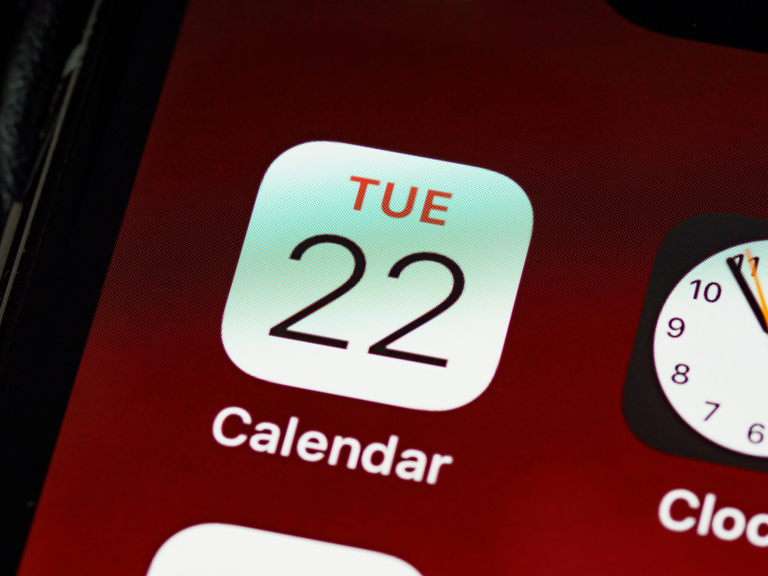 Detailed close-up of an iPhone home screen focused on the calendar app icon.
